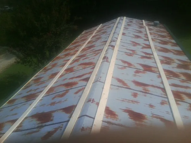 Rusted metal roof panels with new wood purlins before replacement — Storm Damage Roof Repair in Bee by Roofing Brothers