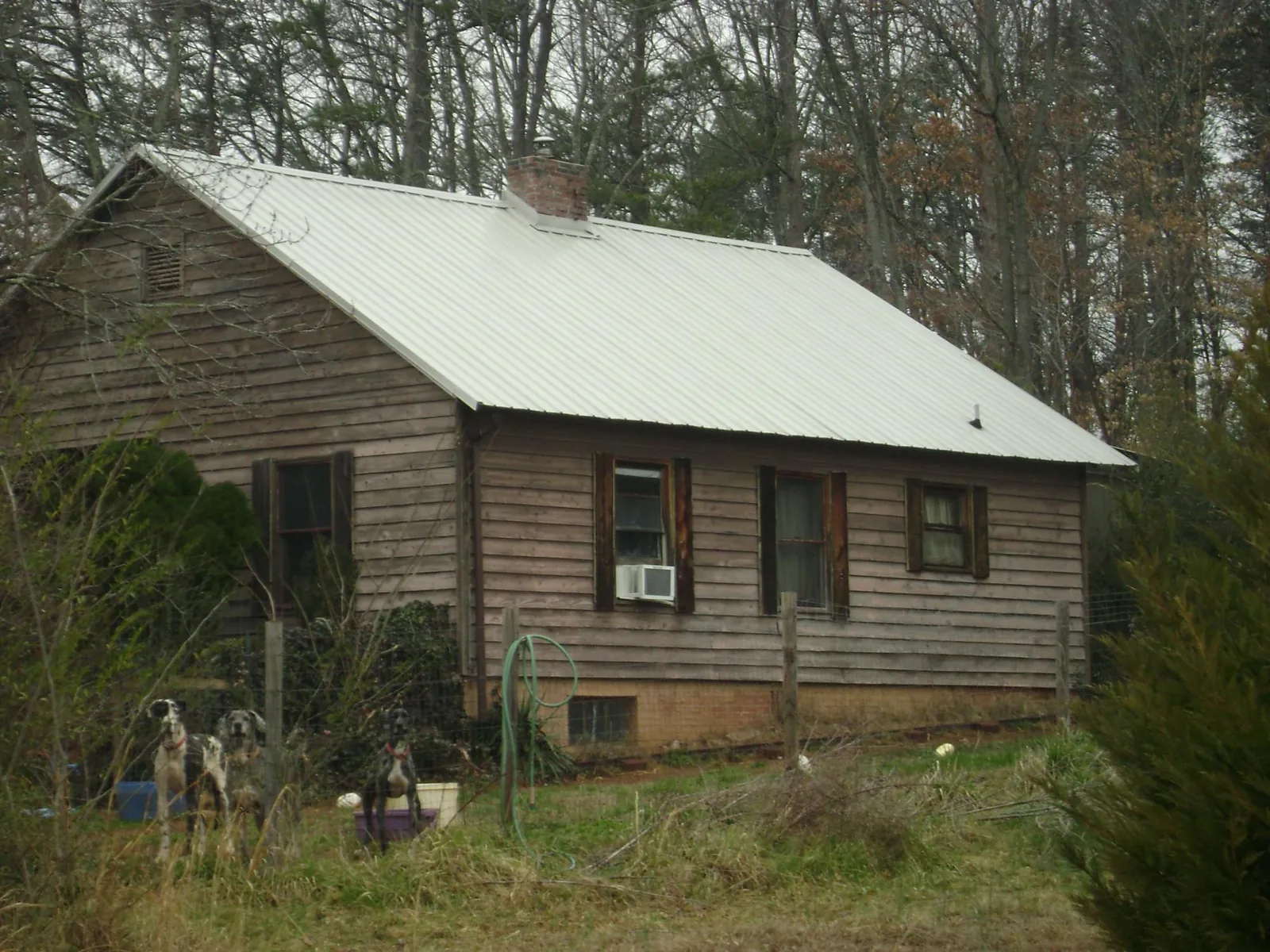 White metal roof on an old wood sided farmhouse, from a Metal Roof Installation job in Bee